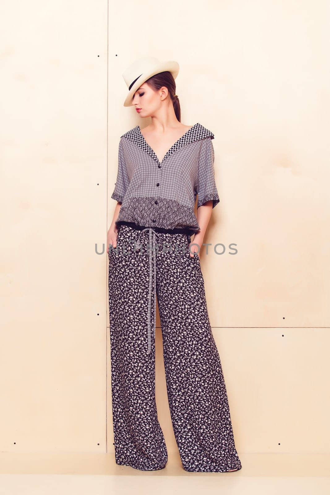 Full height portrait of a young woman in a bright pantsuit