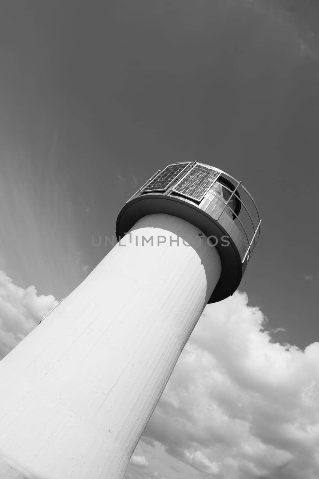 Lighthouse Photovoltaic Sky . Sea Mark at the harbor with blue sky with clouds in background