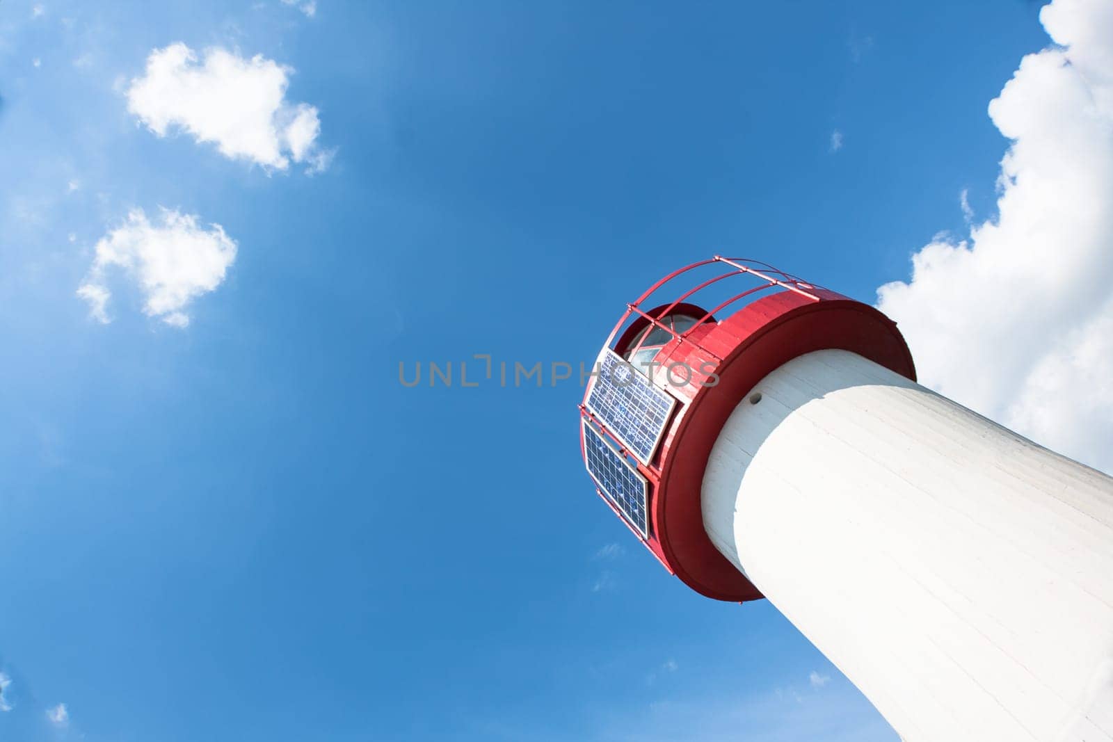 Lighthouse Photovoltaic Sky . Sea Mark at the harbor with blue sky with clouds in background