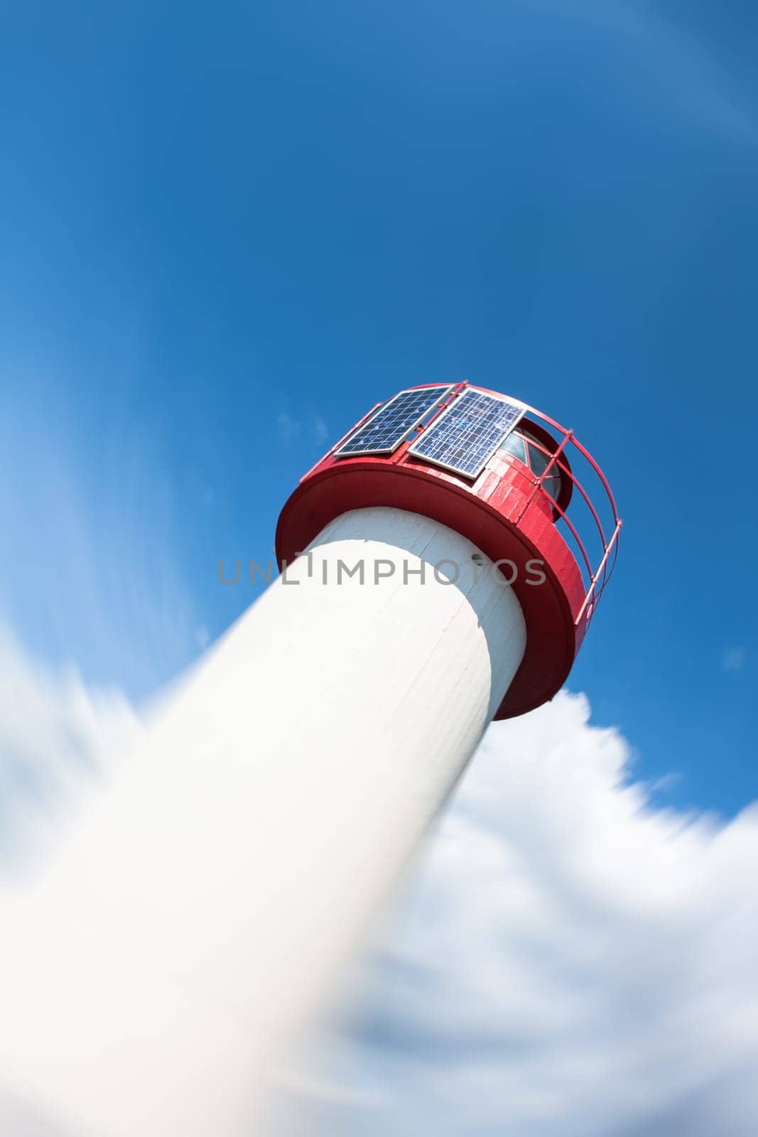 Lighthouse Photovoltaic Sky . Sea Mark at the harbor with blue sky with clouds in background