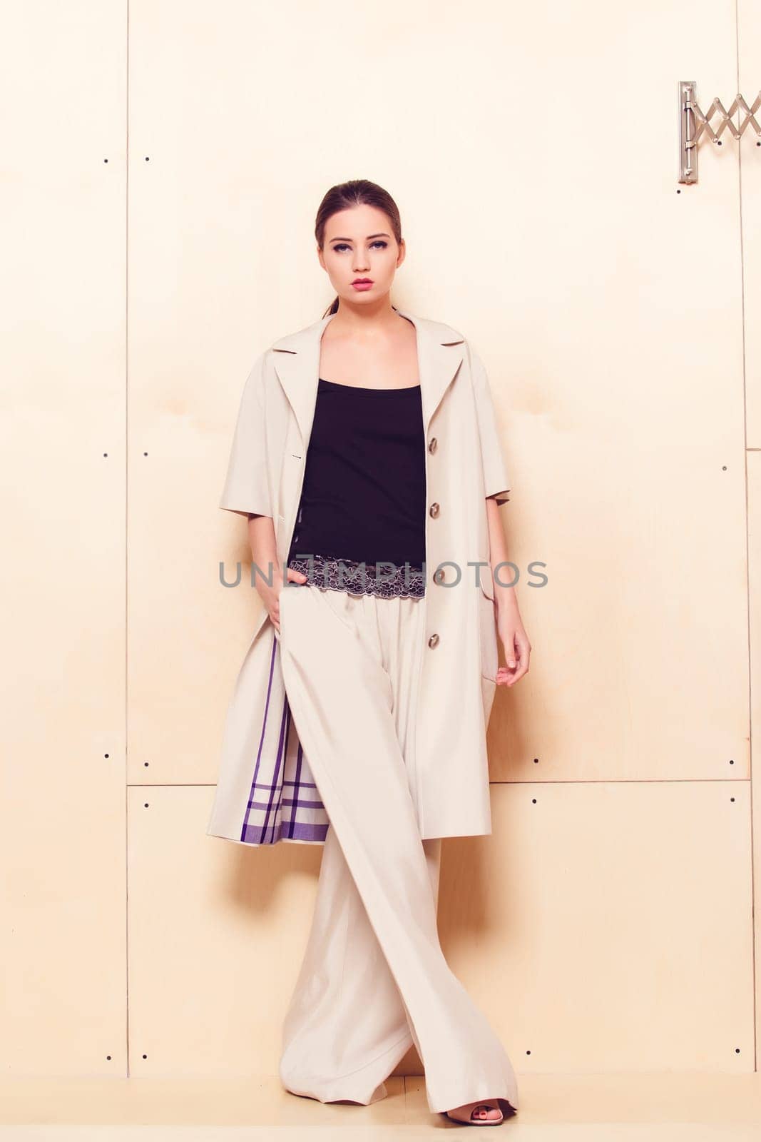 Full height portrait of a young woman in a bright pantsuit