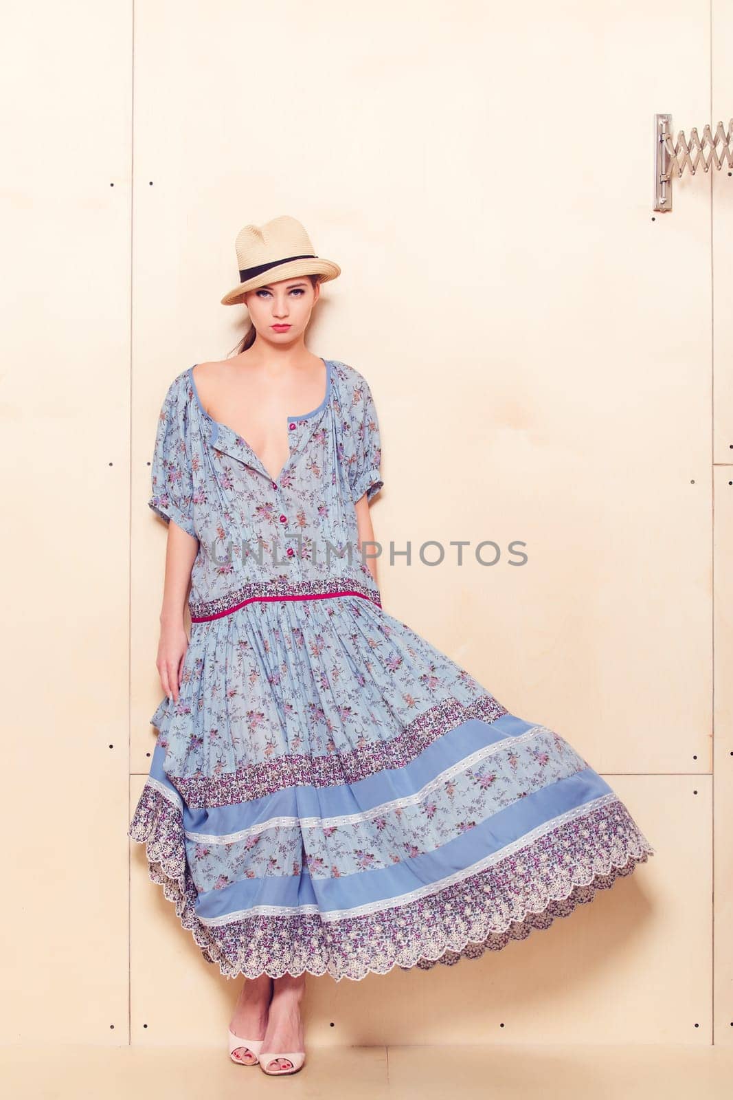 Full body slim woman in blue sundress on wooden background