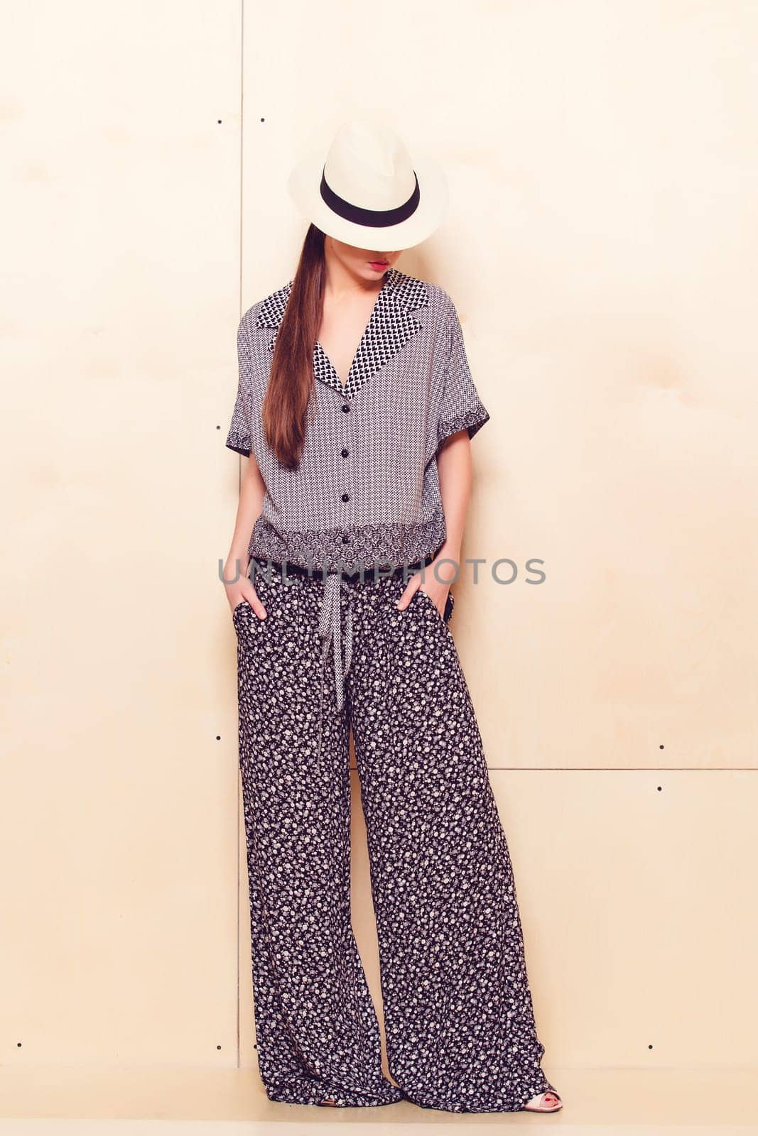 Full height portrait of a young woman in a bright pantsuit