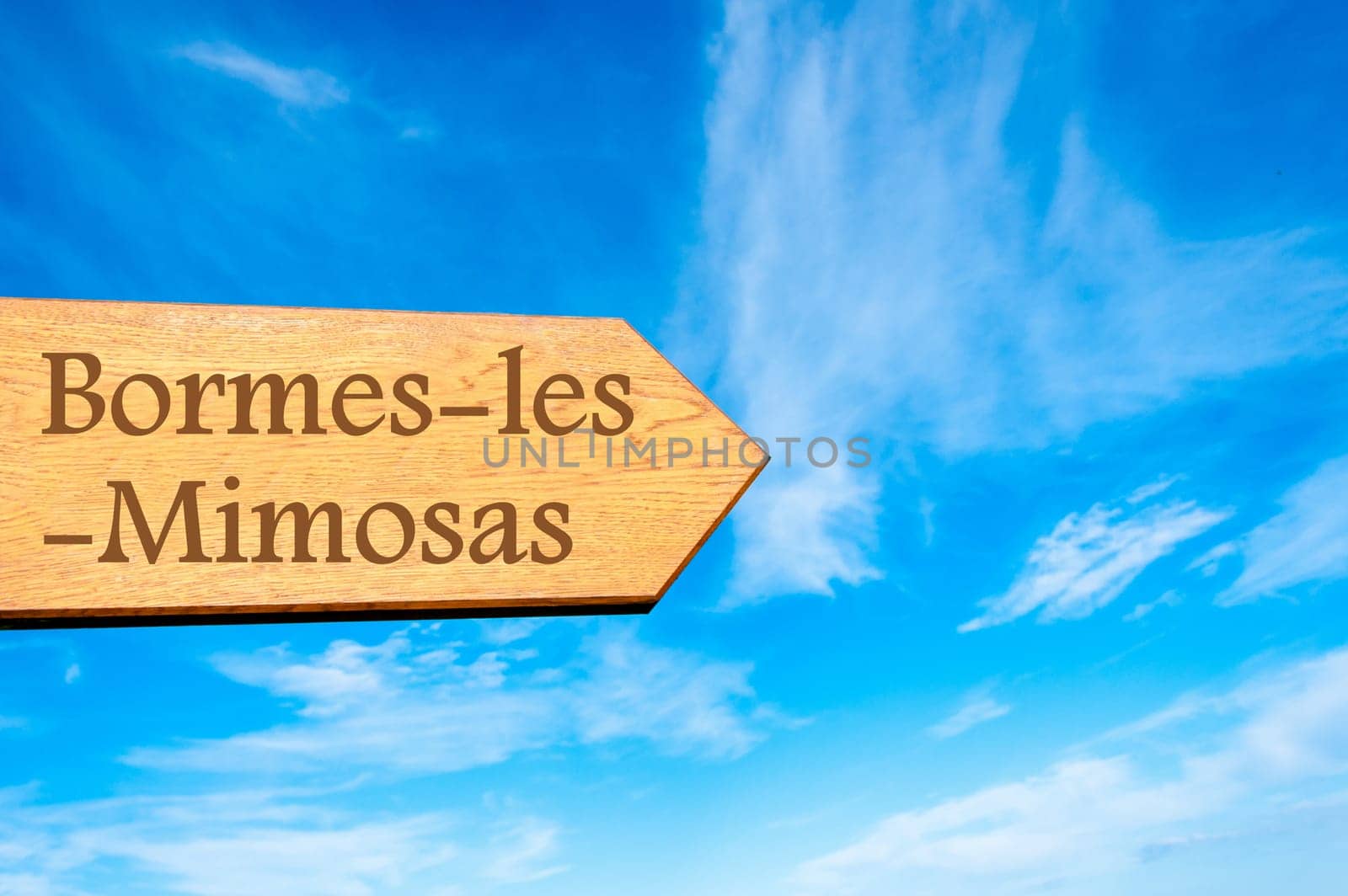 Wooden arrow sign pointing destination Versailles, FRANCE against clear blue sky with copy space available. Travel destination conceptual image