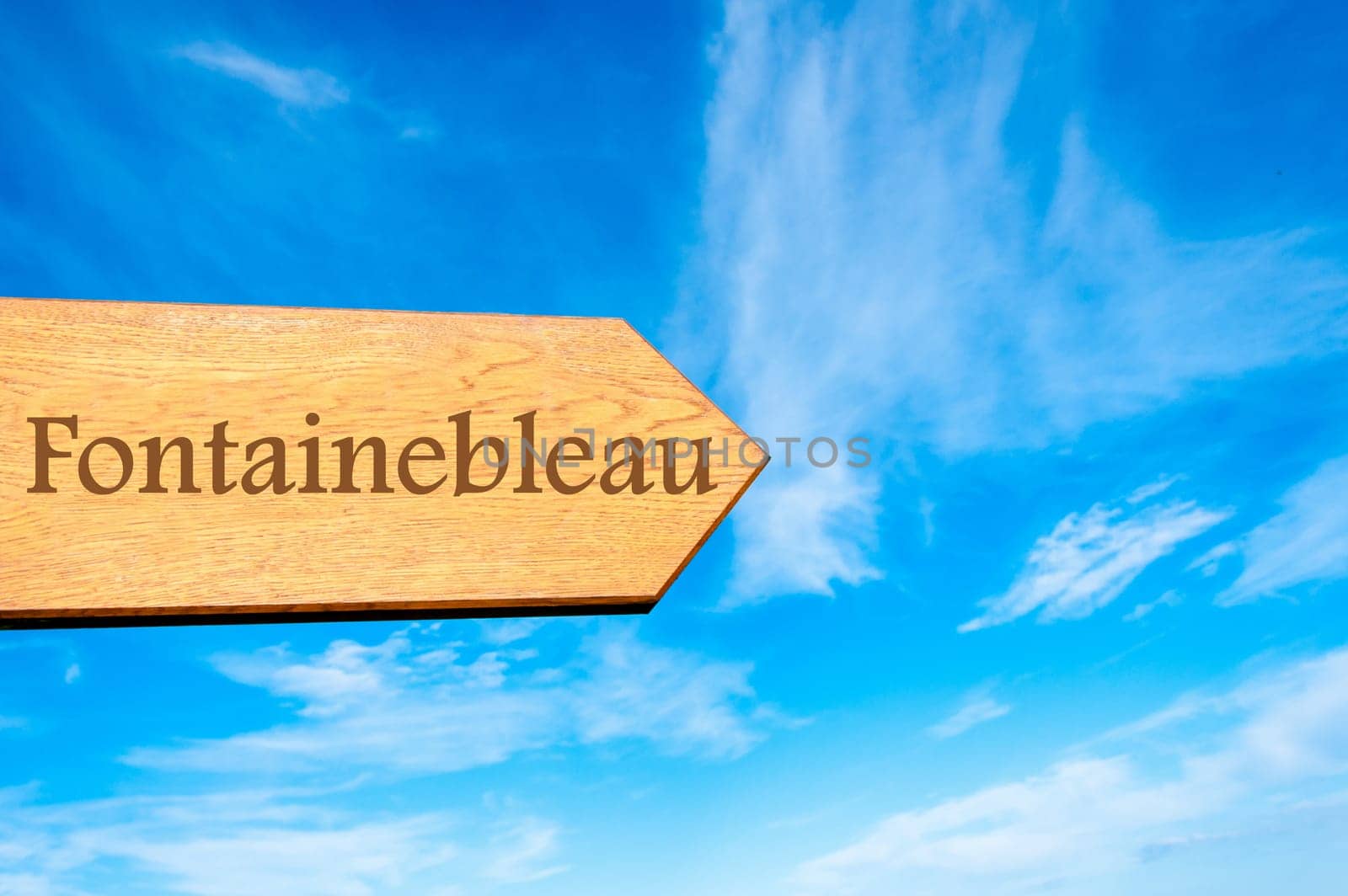 Wooden arrow sign pointing destination Versailles, FRANCE against clear blue sky with copy space available. Travel destination conceptual image