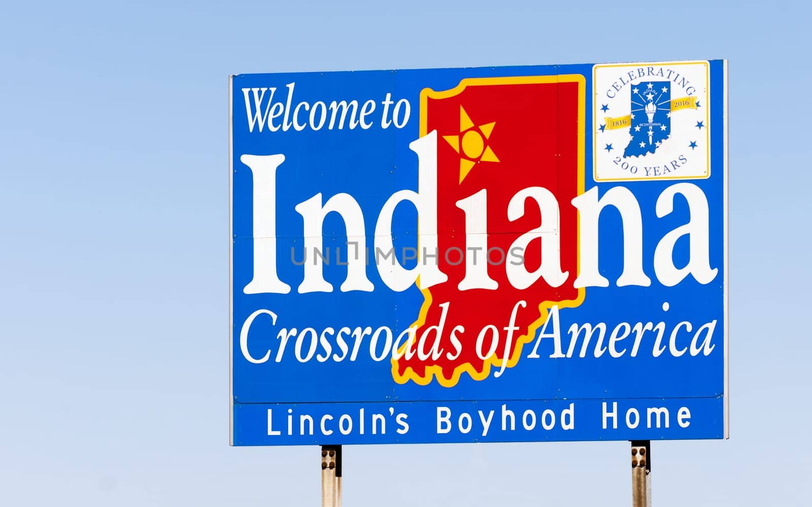 Blue sign against blue sky welcomes you to Indiana