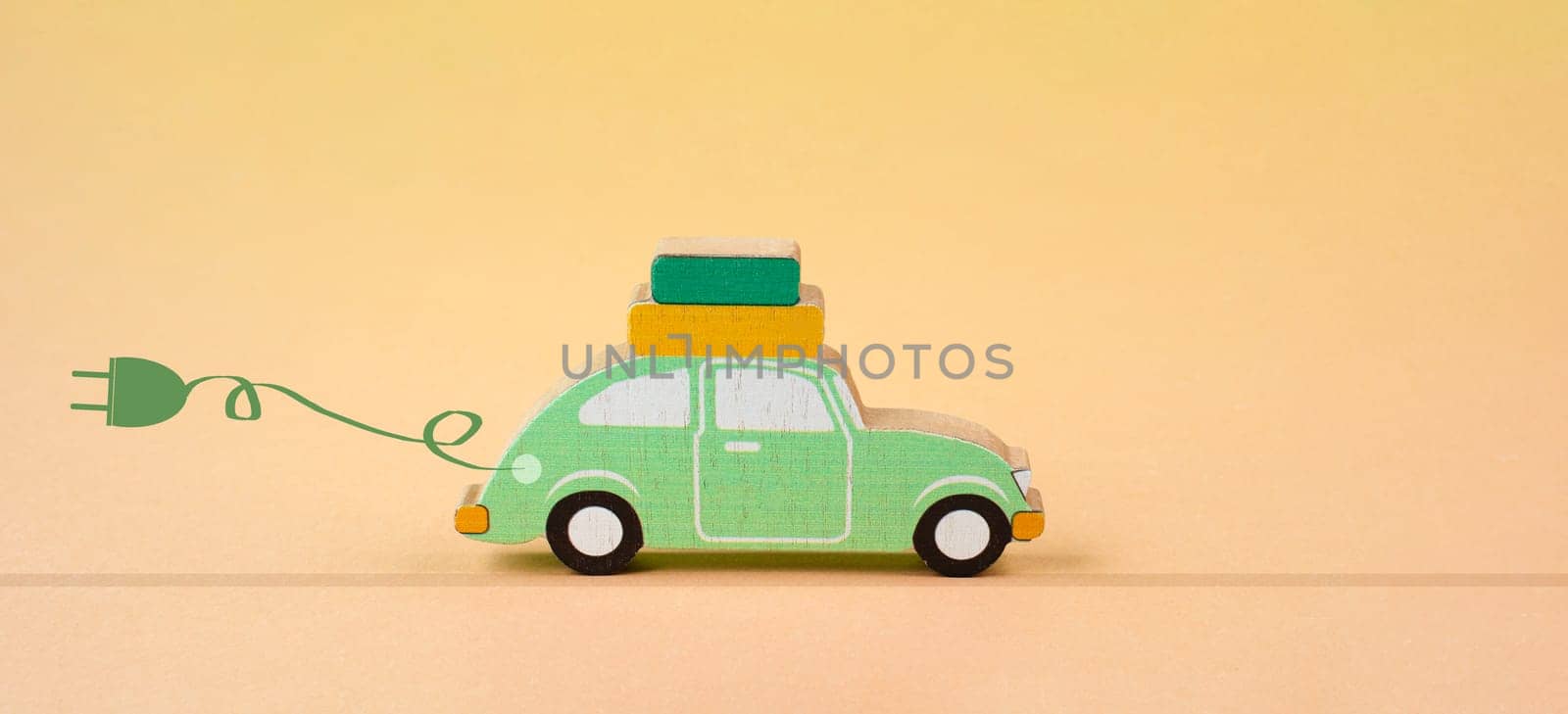 Small blue electric car with a cable for recharging, vacation trip with eco power