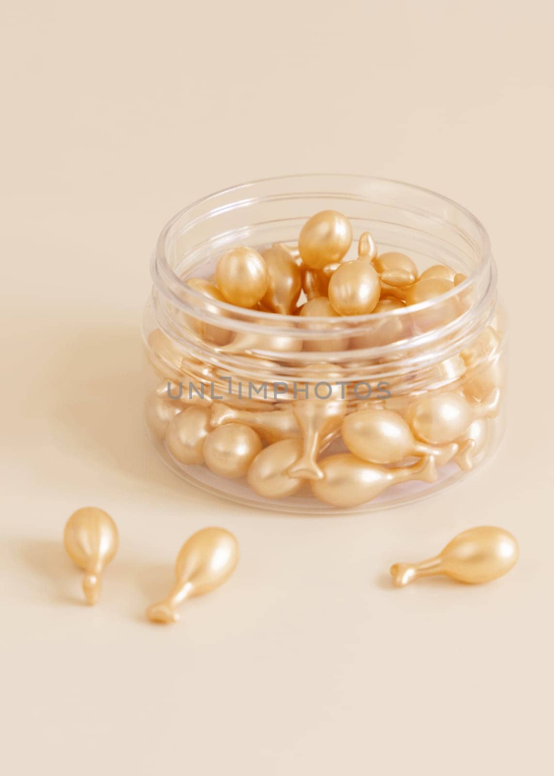 Beauty serum capsules in a jar on light yellow close up. Skincare cosmetics. Facial treatment with perfect dosage of serum to be used. Pastel minimal composition..