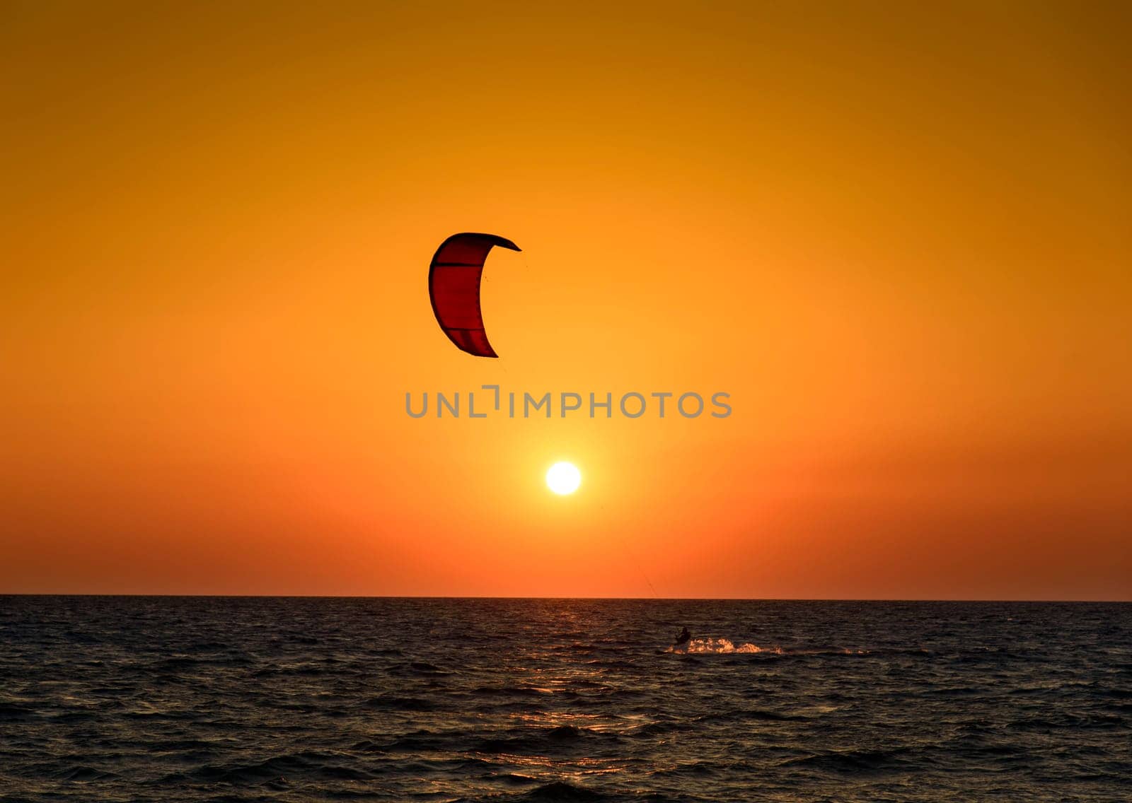 Kite surfer silhouette at beautiful sunset at the sea
