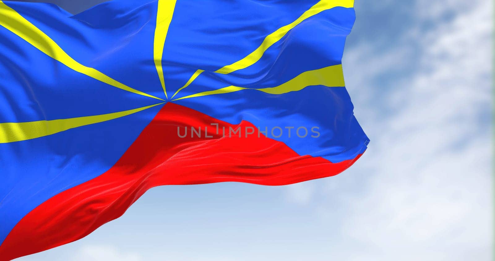 The flag of Reunion waving in the wind on a clear day. Reunion is an island in the Indian Ocean that is an overseas department and region of France
