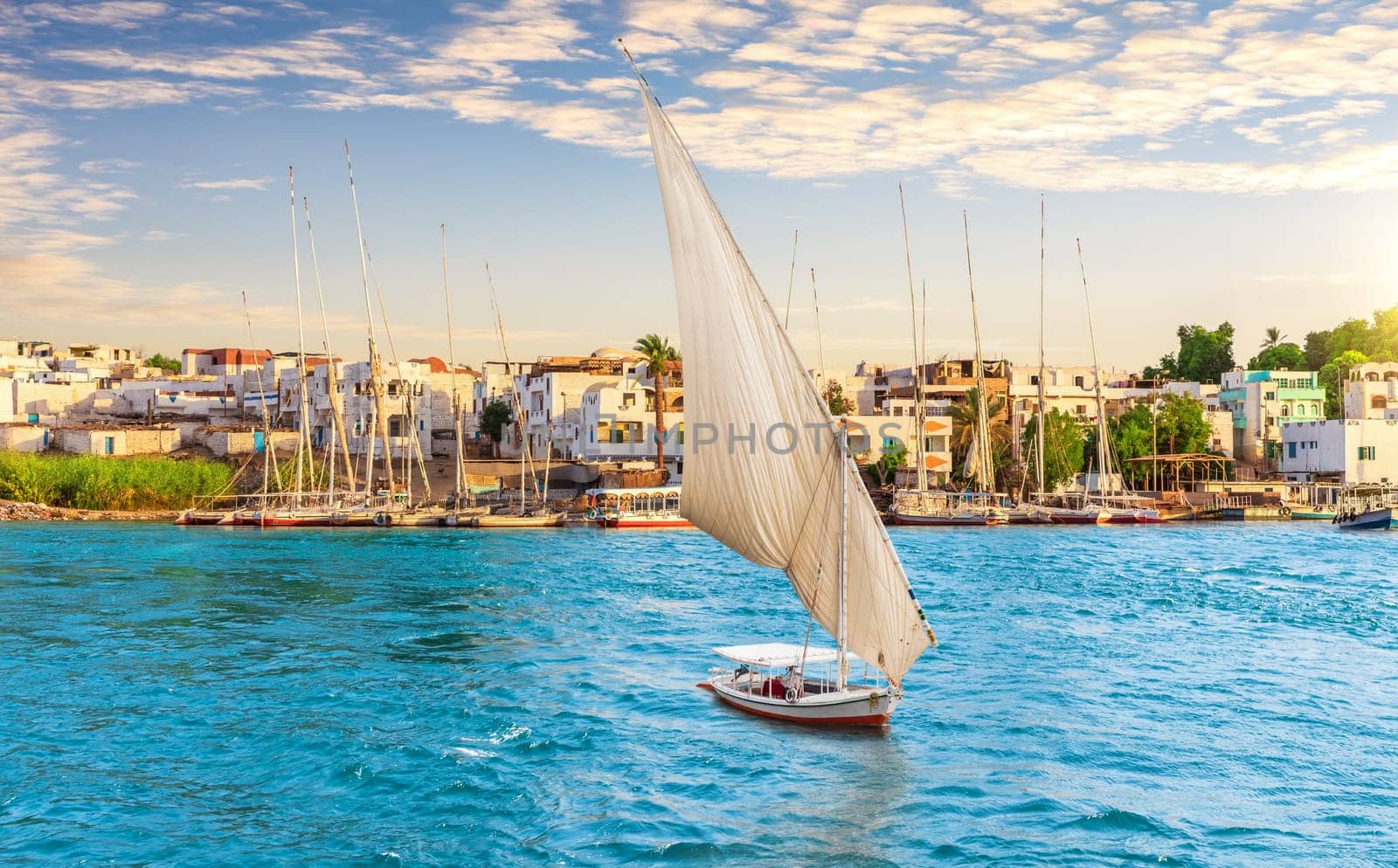 Traditional buildings of Aswan city and Sailboat on the Nile, Egypt.