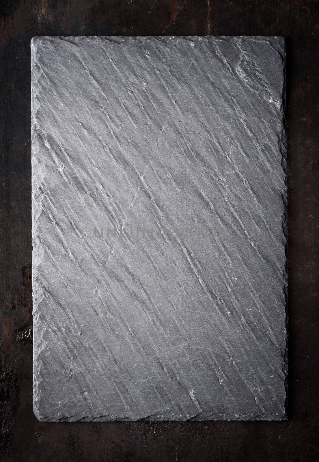 Black textured sushi slate board background with copyspace.