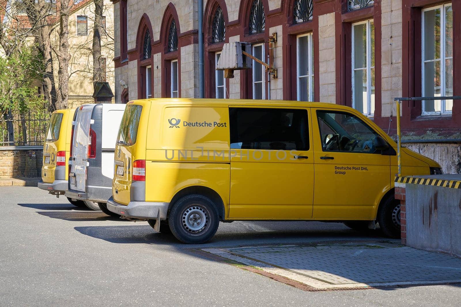 Vehicles of the Deutsche Post company in front of a post office in downtown Wittenberg