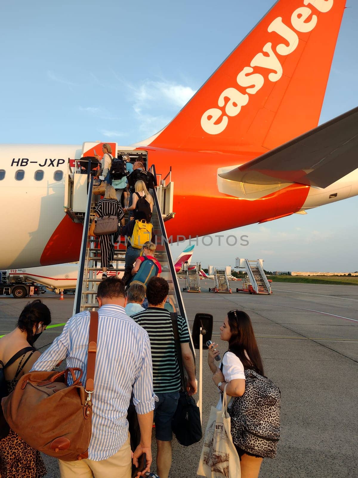 An easyJet aircraft at Hamburg Airport is being prepared for take-off. Passengers at the gate board the plane. Theme Image - Travel Photography