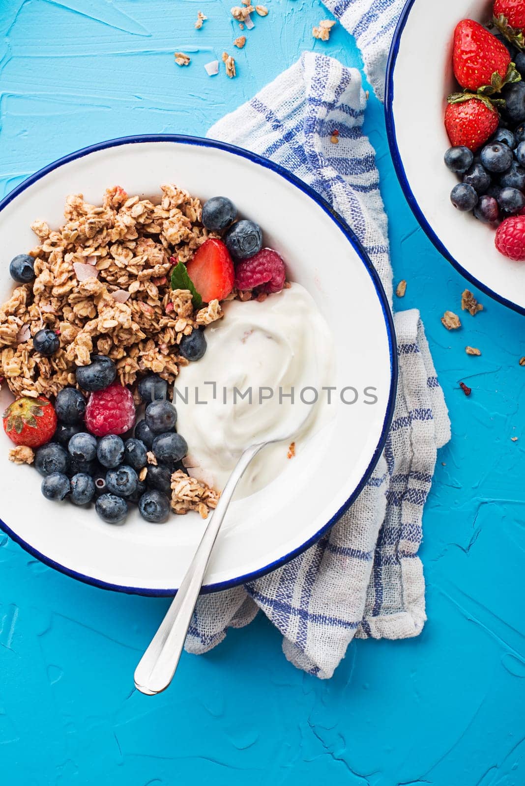 A plate of dry granola served with fresh berry fruit and yogurt. Oatmeal plate. Healthy food, diet. Top view.