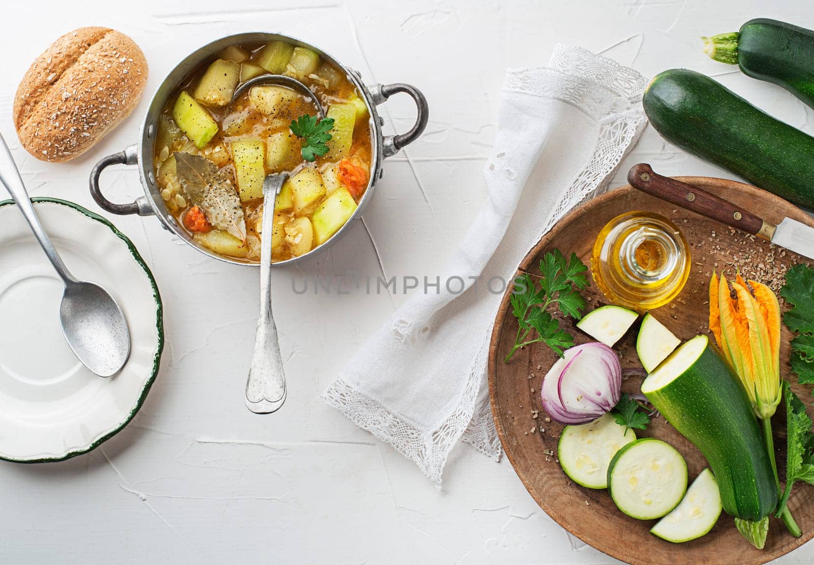 Serving freshly prepared hot zucchini stew or soup on white background. Vegetable stew