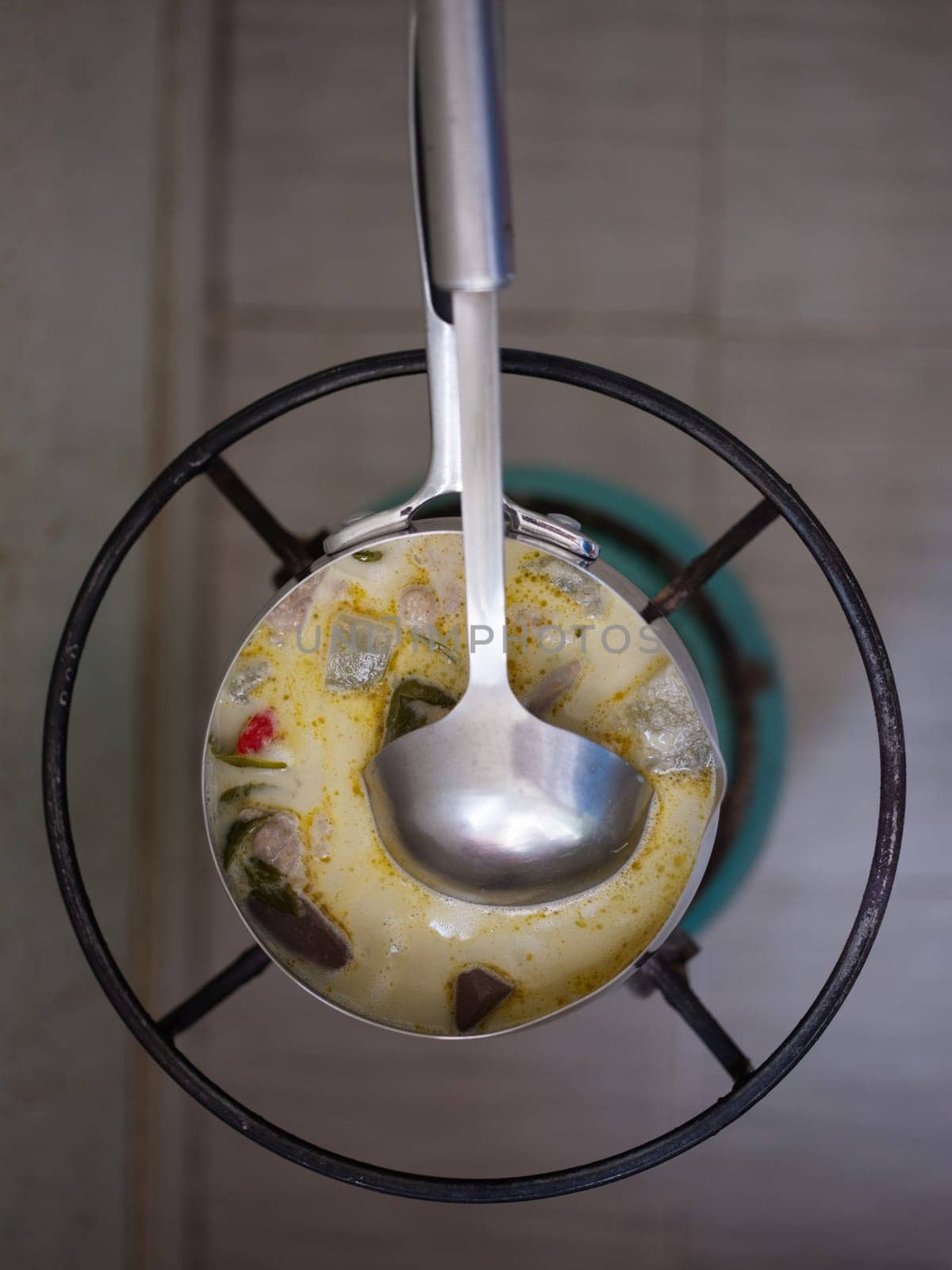 Green curry with chicken (Kang Keaw Wan Gai) with herb on gas stove
