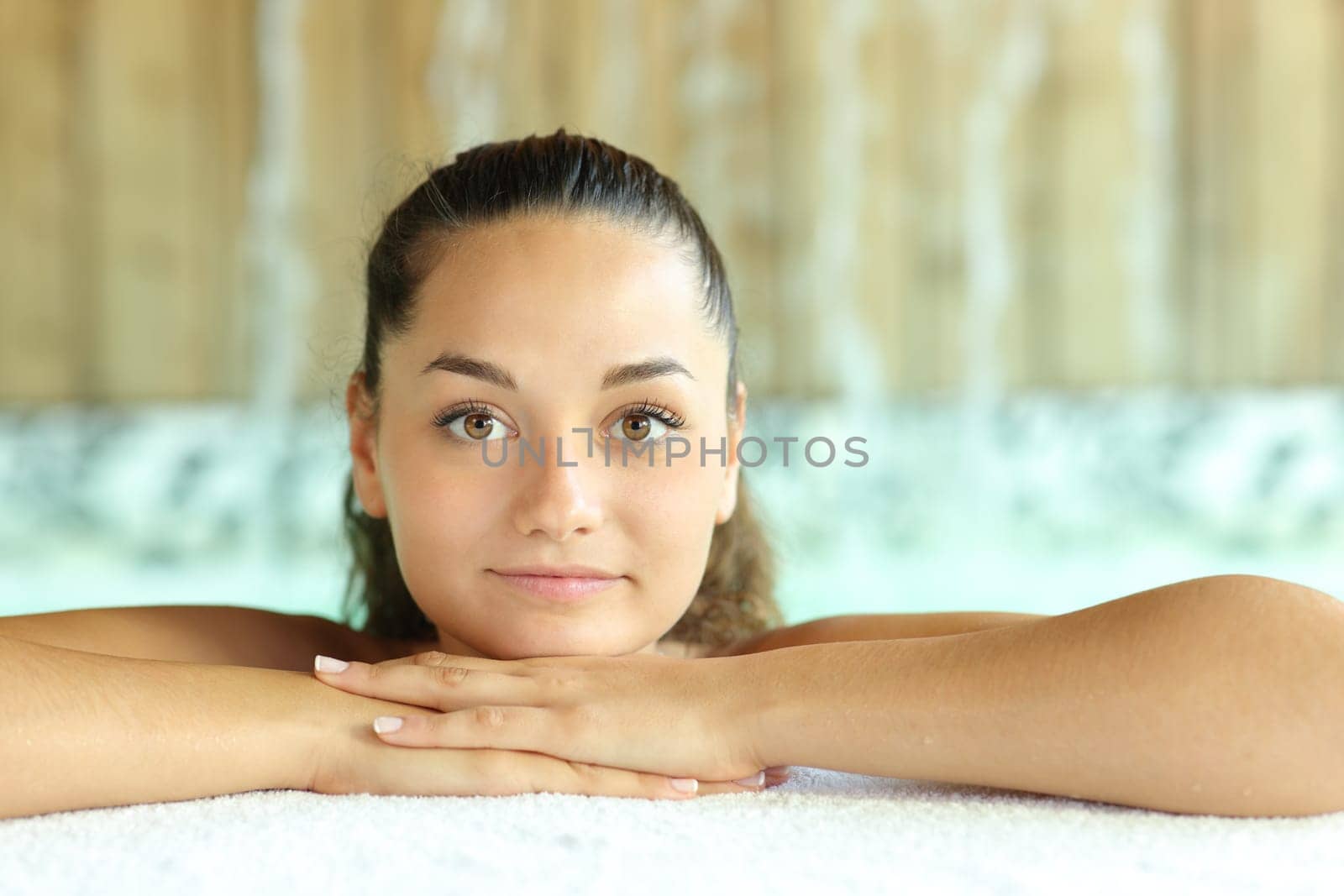Front view portrait of a beauty woman looking at camera in spa pool