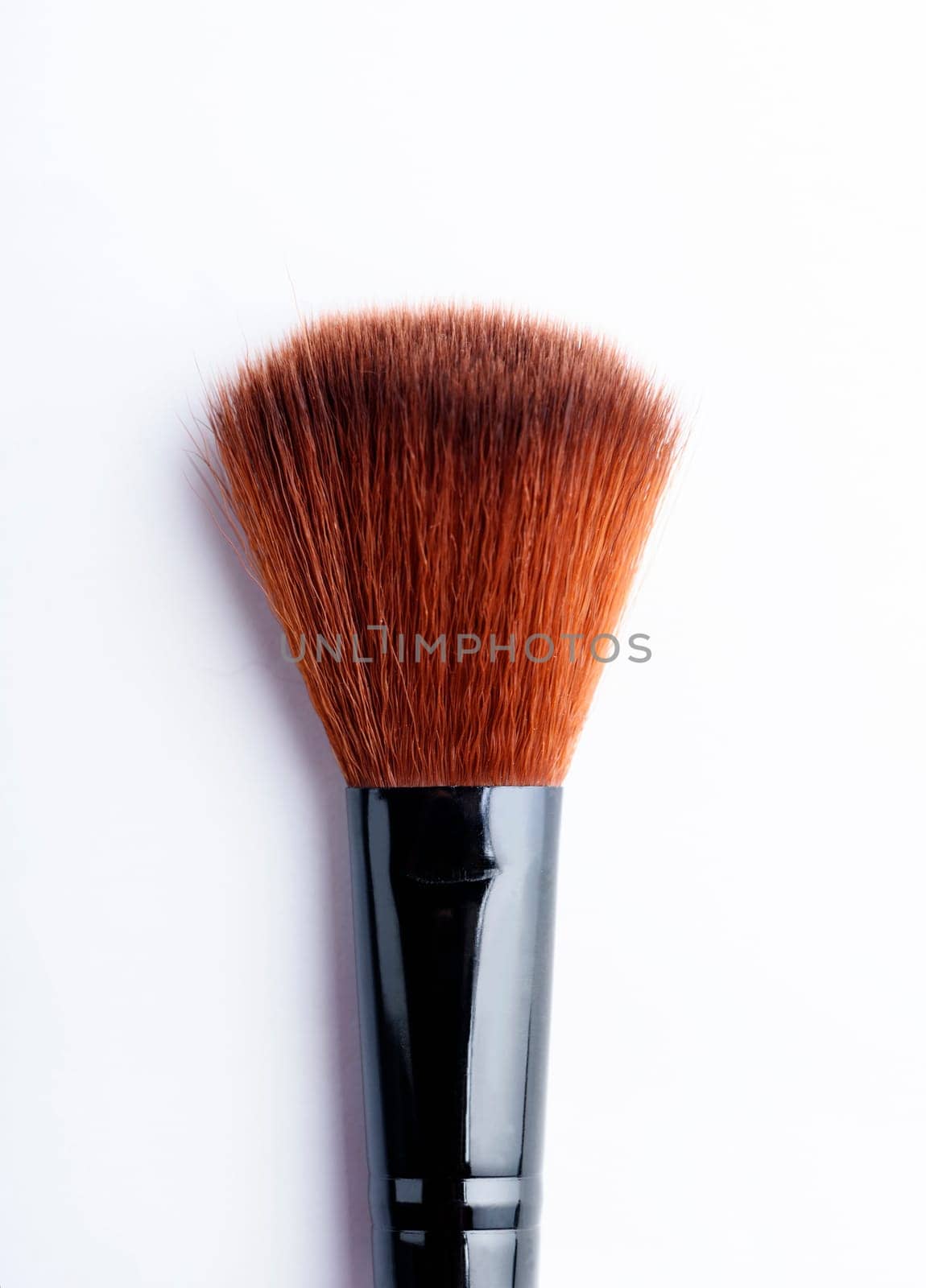 Professional makeup brush closeup isolated over white background.