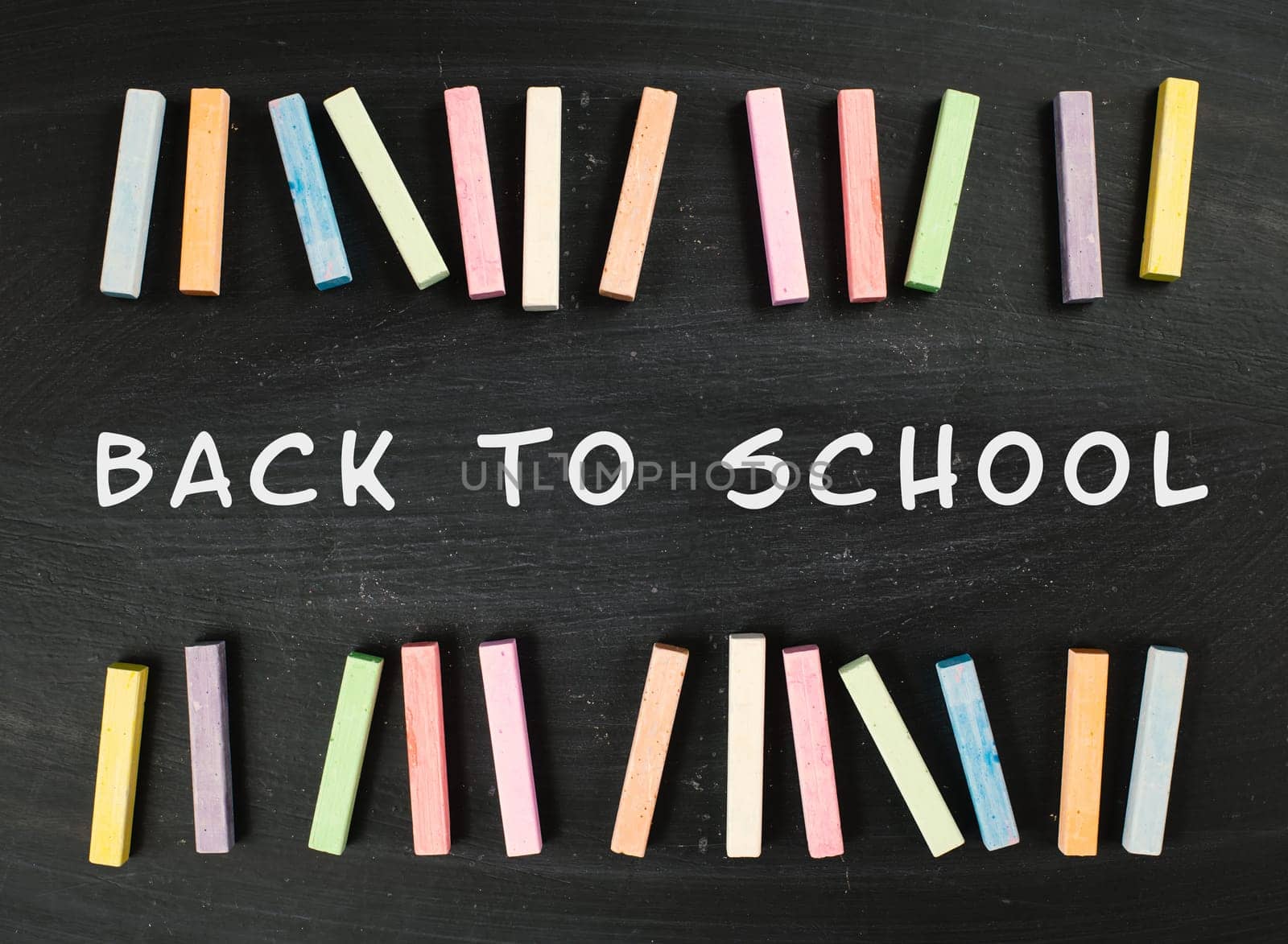 Chalkboard with the text back to school, education concept, colorful chalk