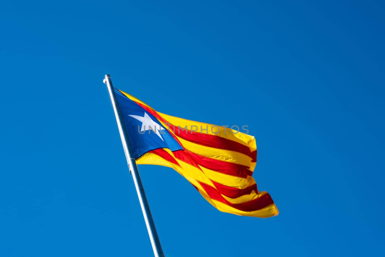 The Senyera Estelada flag, four red stripes on a yellow field and a blue triangle with a star on the left side, symbol of the claim of independence of the autonomous community of Catalonia with the Spanish state.