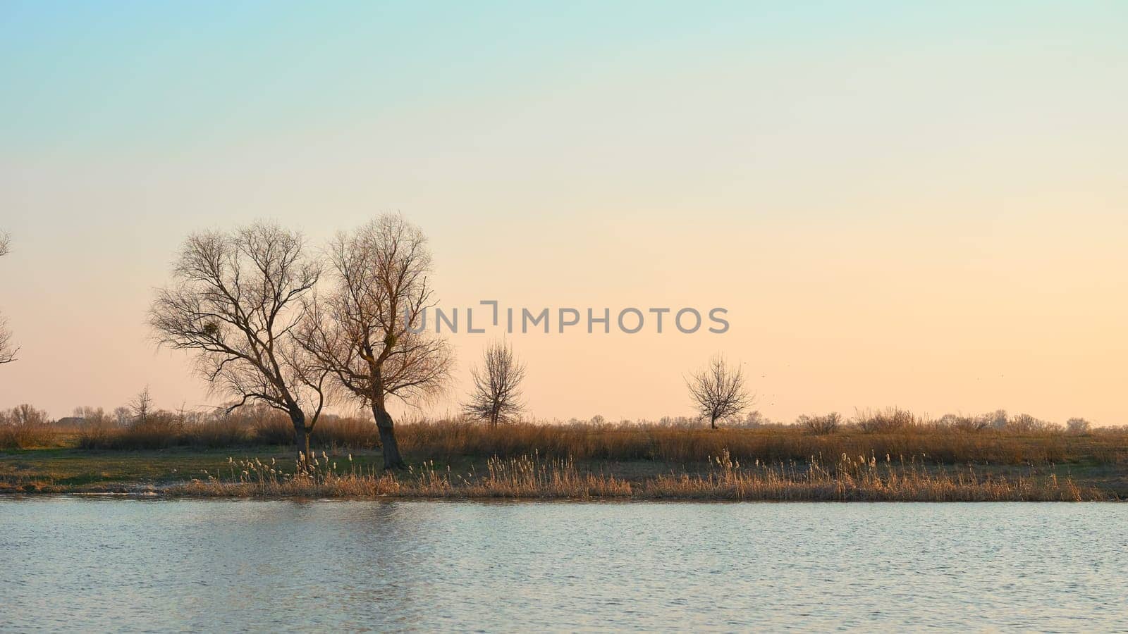the season after winter and before summer, in which vegetation begins to appear. Beautiful sunset on the river in early spring