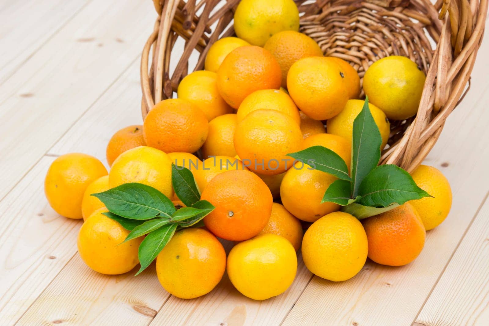 fresh tangerines in a basket on wooden background