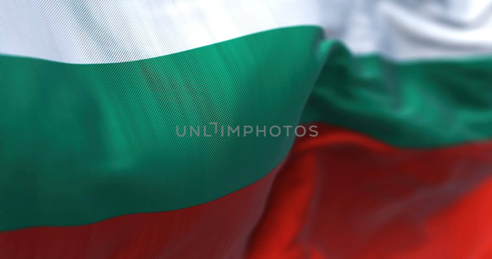 Close-up view of the Bulgarian national flag waving in the wind. Bulgaria is a country in Southeast Europe. Fabric textured background. Selective focus