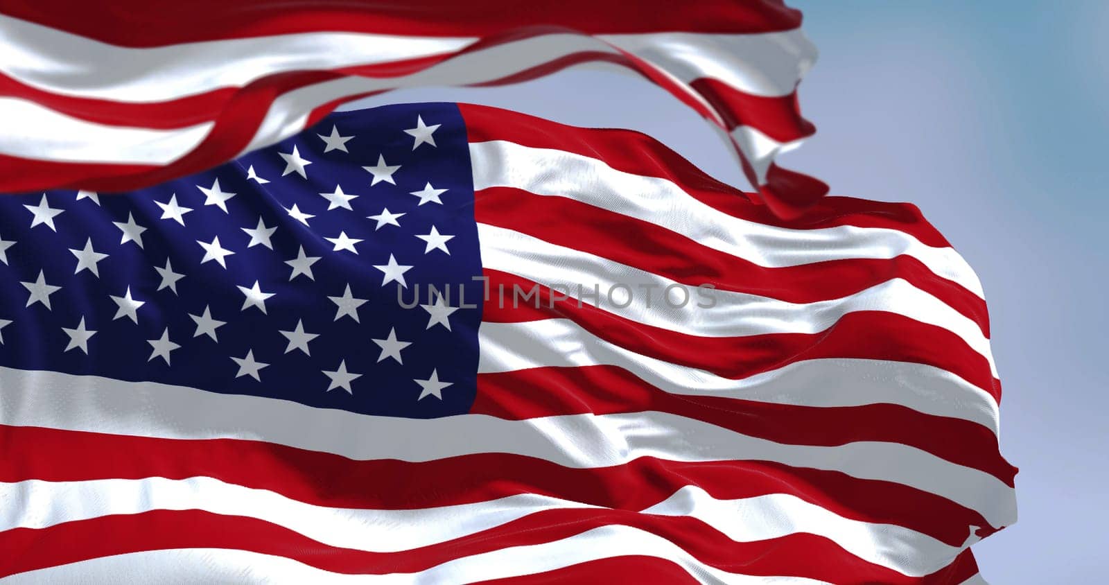 Flags of the United States of America waving in the wind. Clear sky in the background. Selective focus. Democracy, independence and election day. Patriotic symbol of American pride