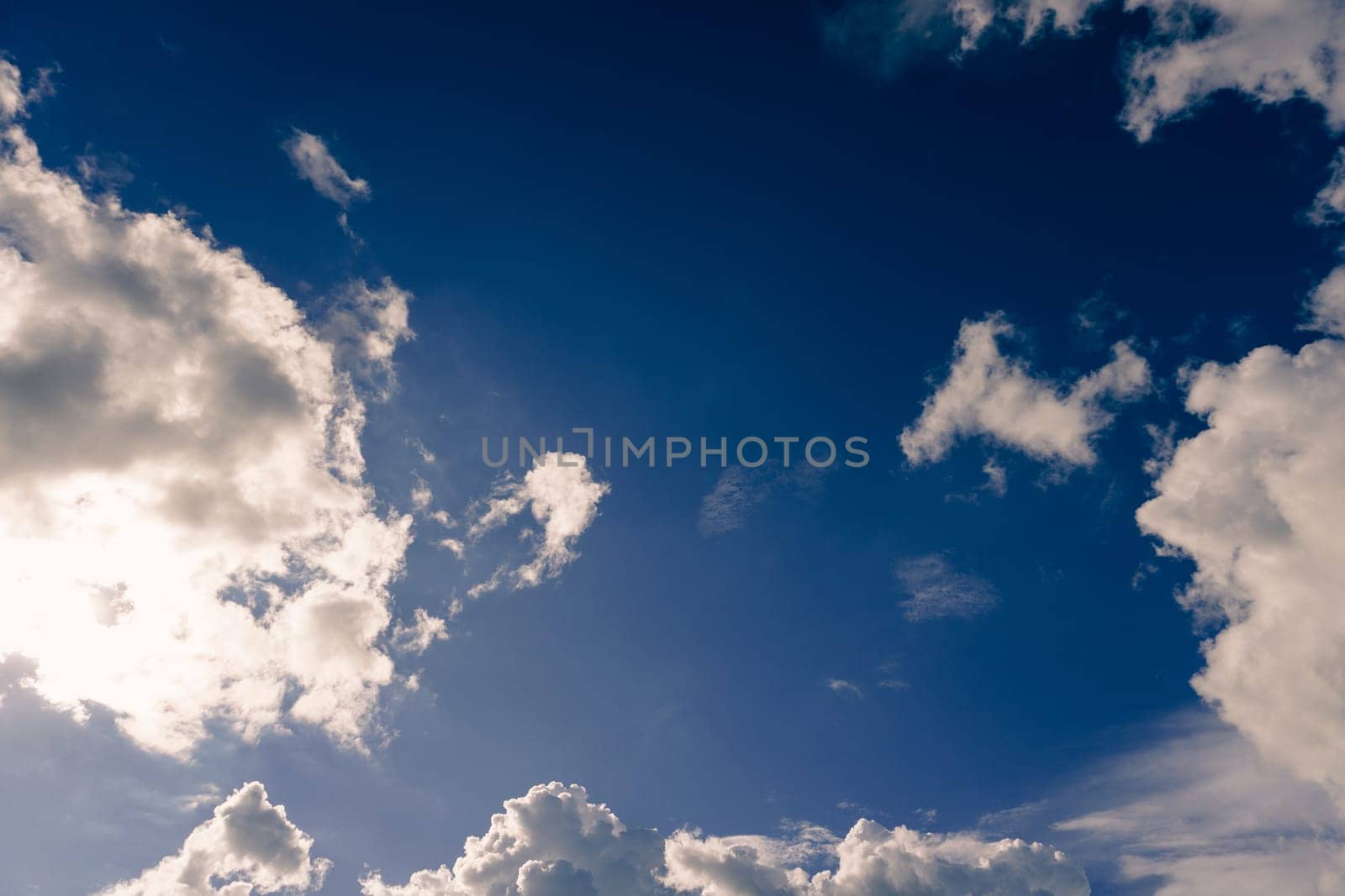 Blue sky with clouds and sun shines bright in the daytime in summer