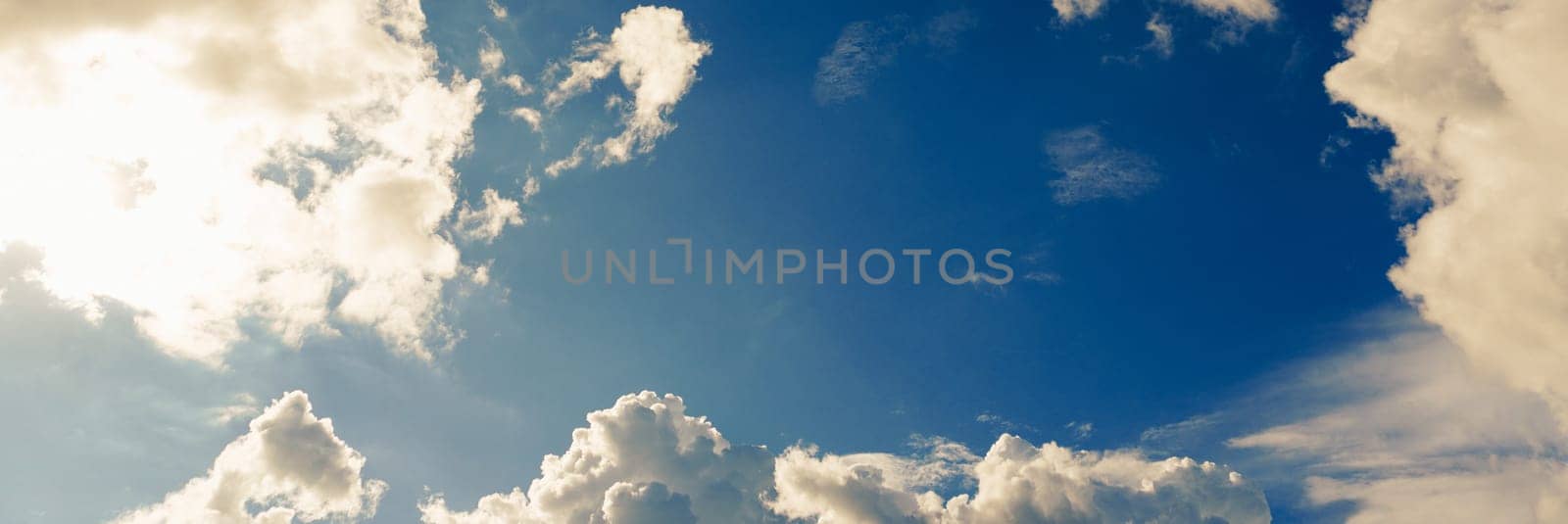 Blue sky with clouds and sun shines bright in the daytime in summer