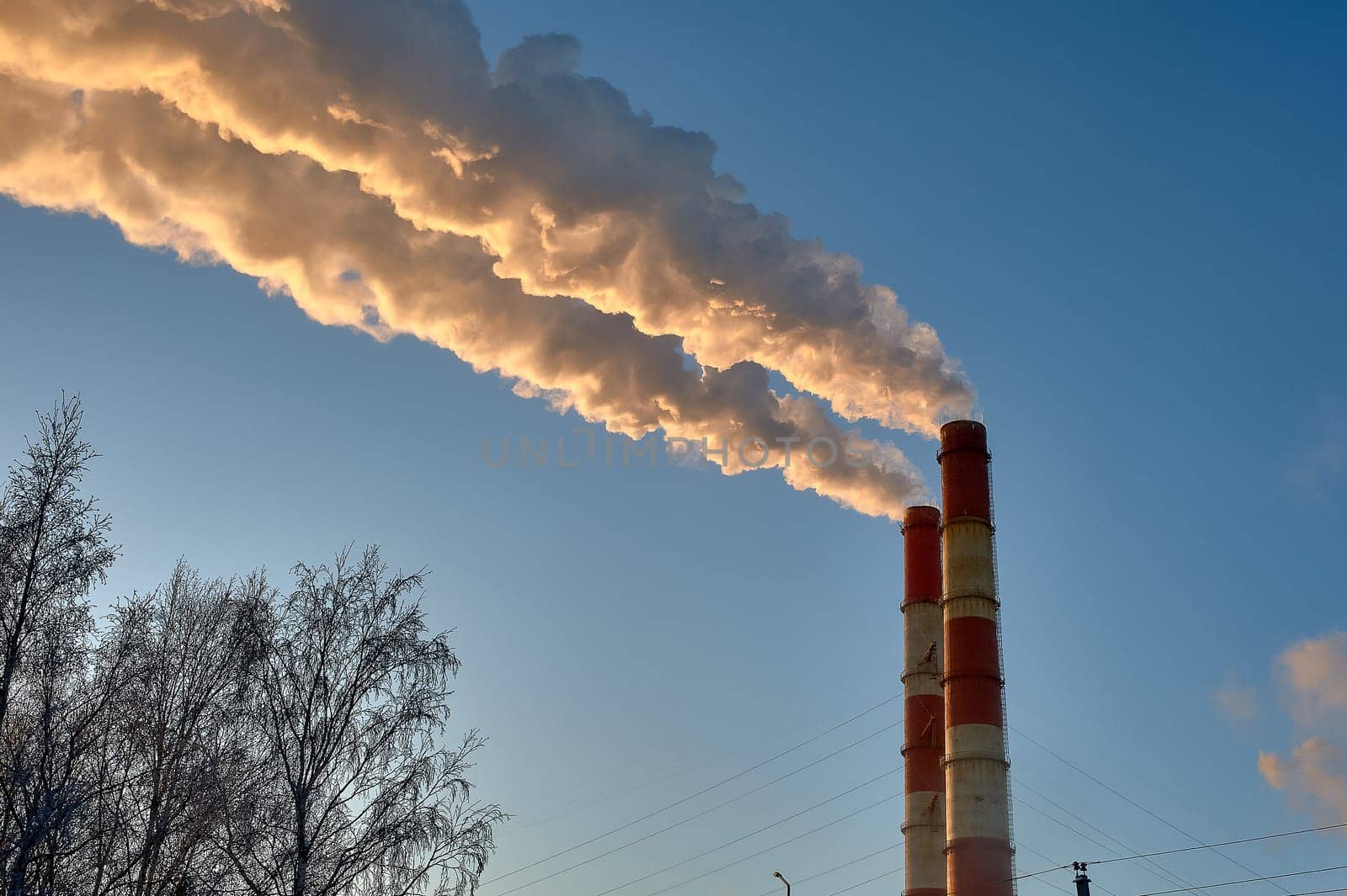 white smoke is coming out of the pipes in the blue sky. High quality photo