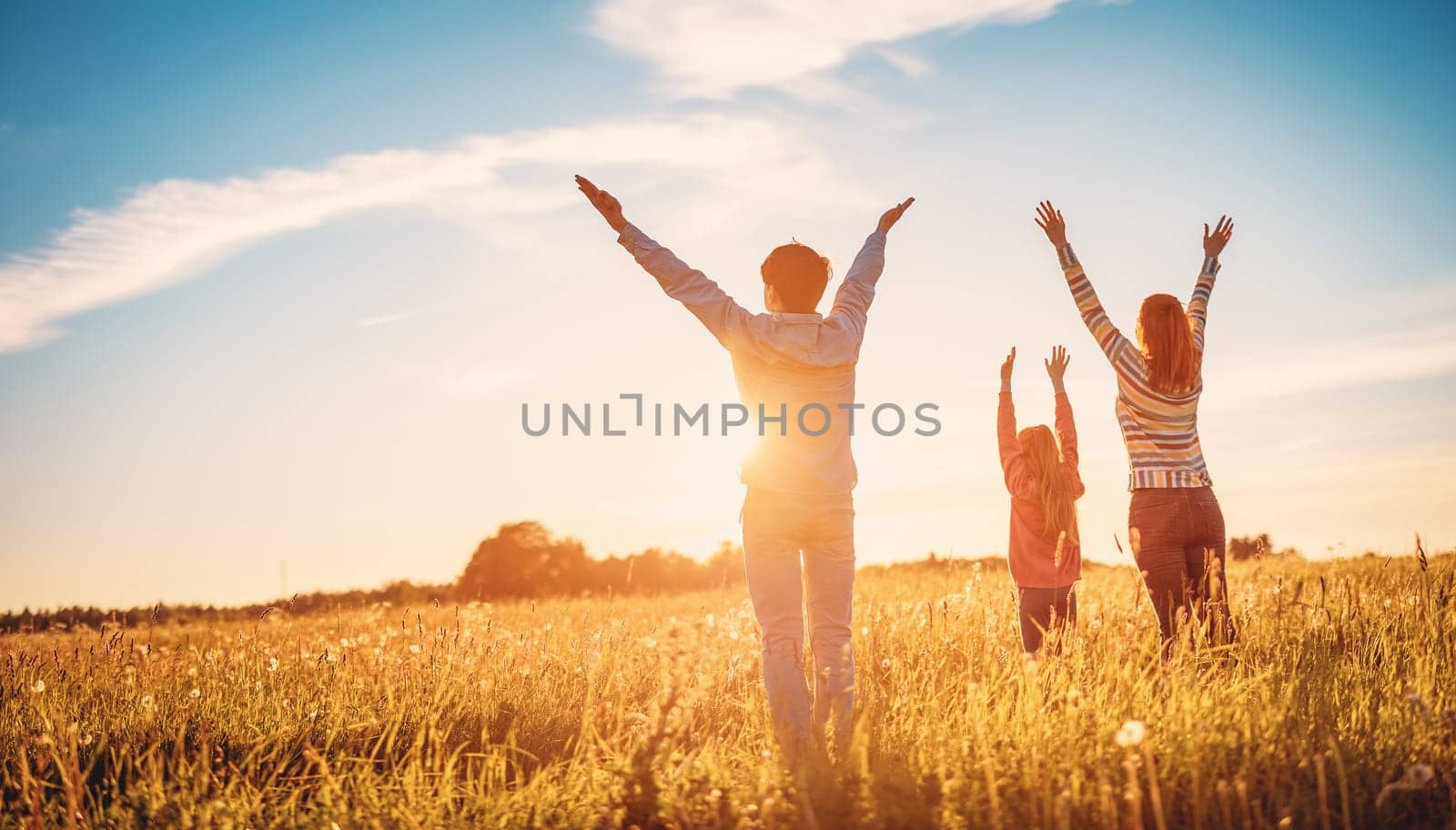 Happy family in the nature together on the evening sunset. Panoramic view. Concept of the vacation and relationship.