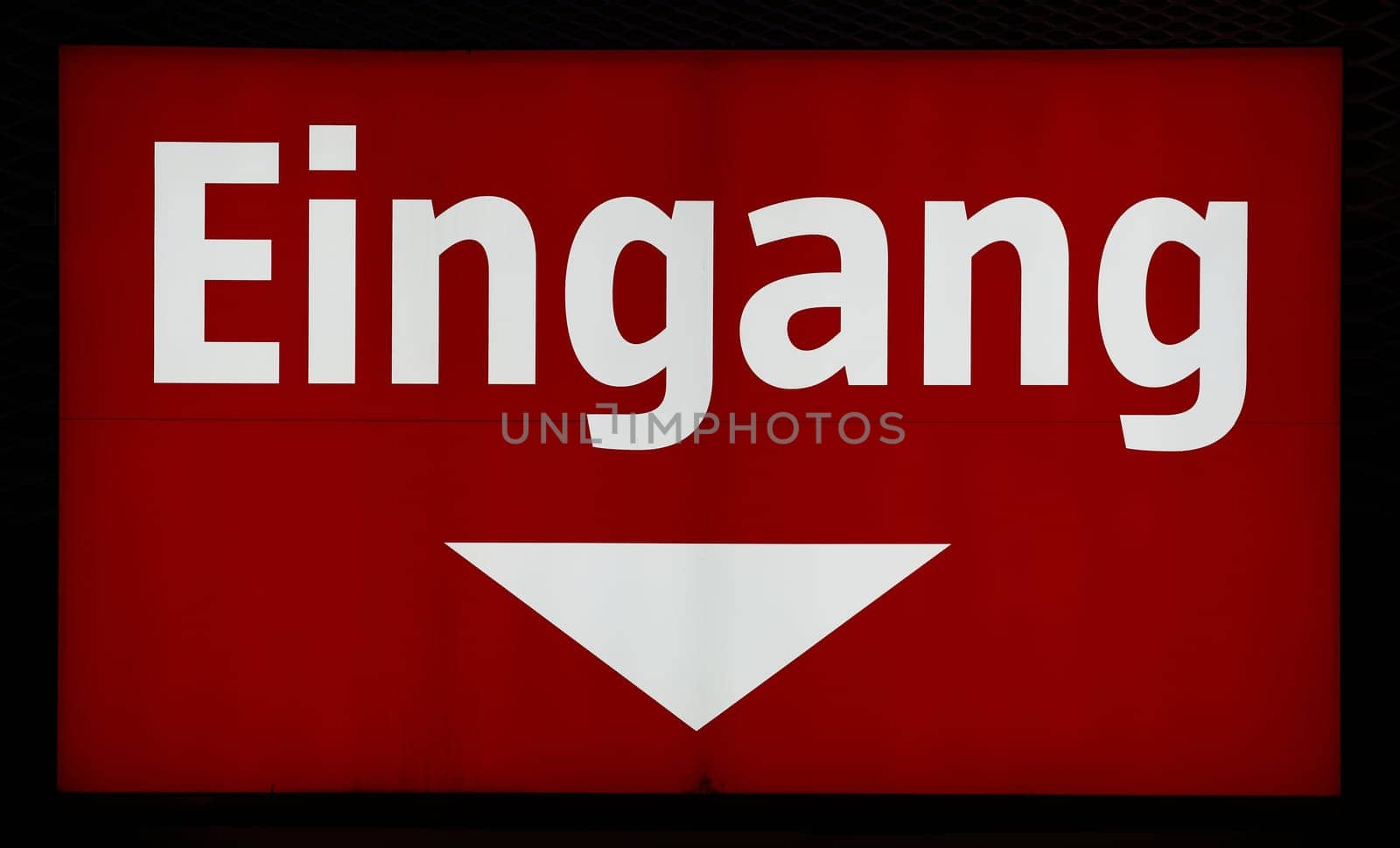 illuminated red sign at the entrance to a store in Germany. Translation: entrance