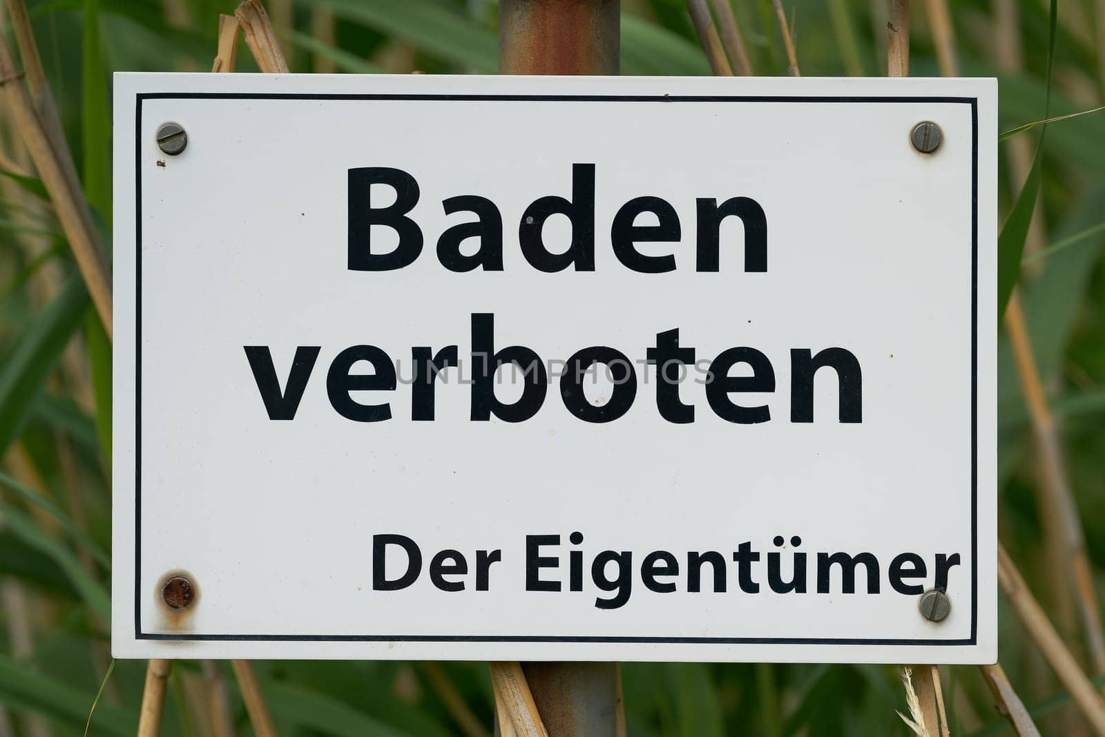 Prohibition sign at a private lake in Germany. Translation: Bathing prohibited, the owner