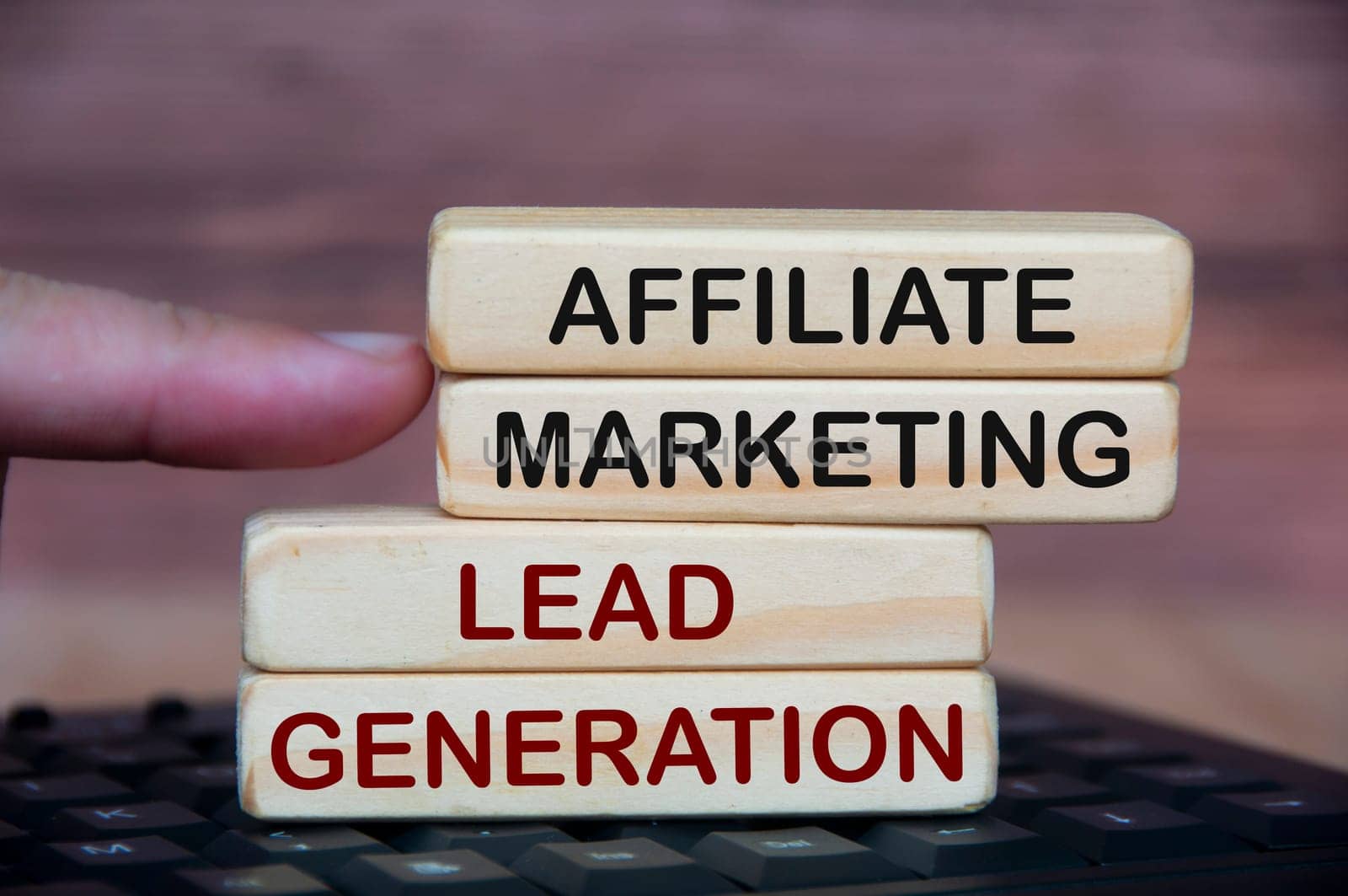Affiliate marketing and lead generation text on wooden block on top of keyboard. Online business concept