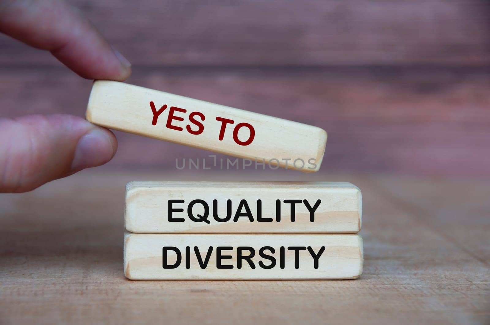 Hand holding yes to equity and diversity text on wooden blocks. Business culture concept.