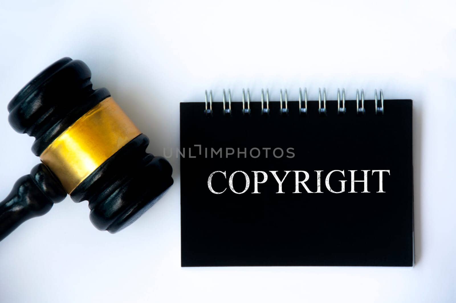 Copyright law text on black notepad and gavel on white background cover. Copyright law concept