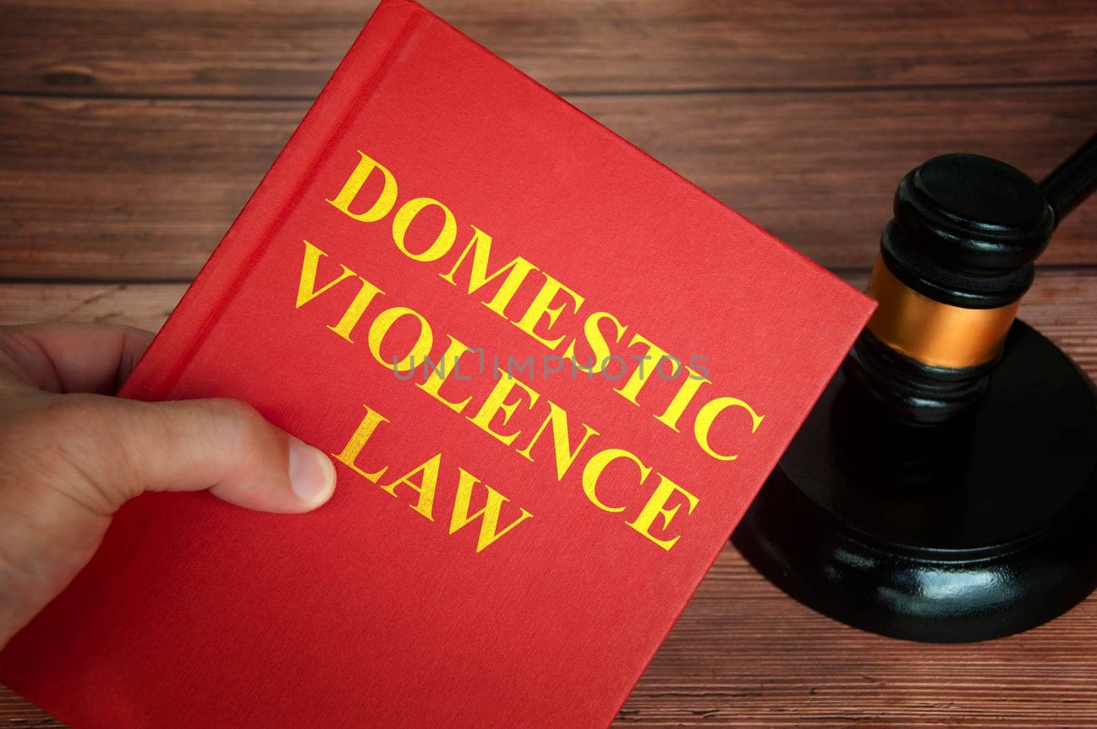 Domestic violence law text on law book with judge gavel on wooden desk background. Law concept