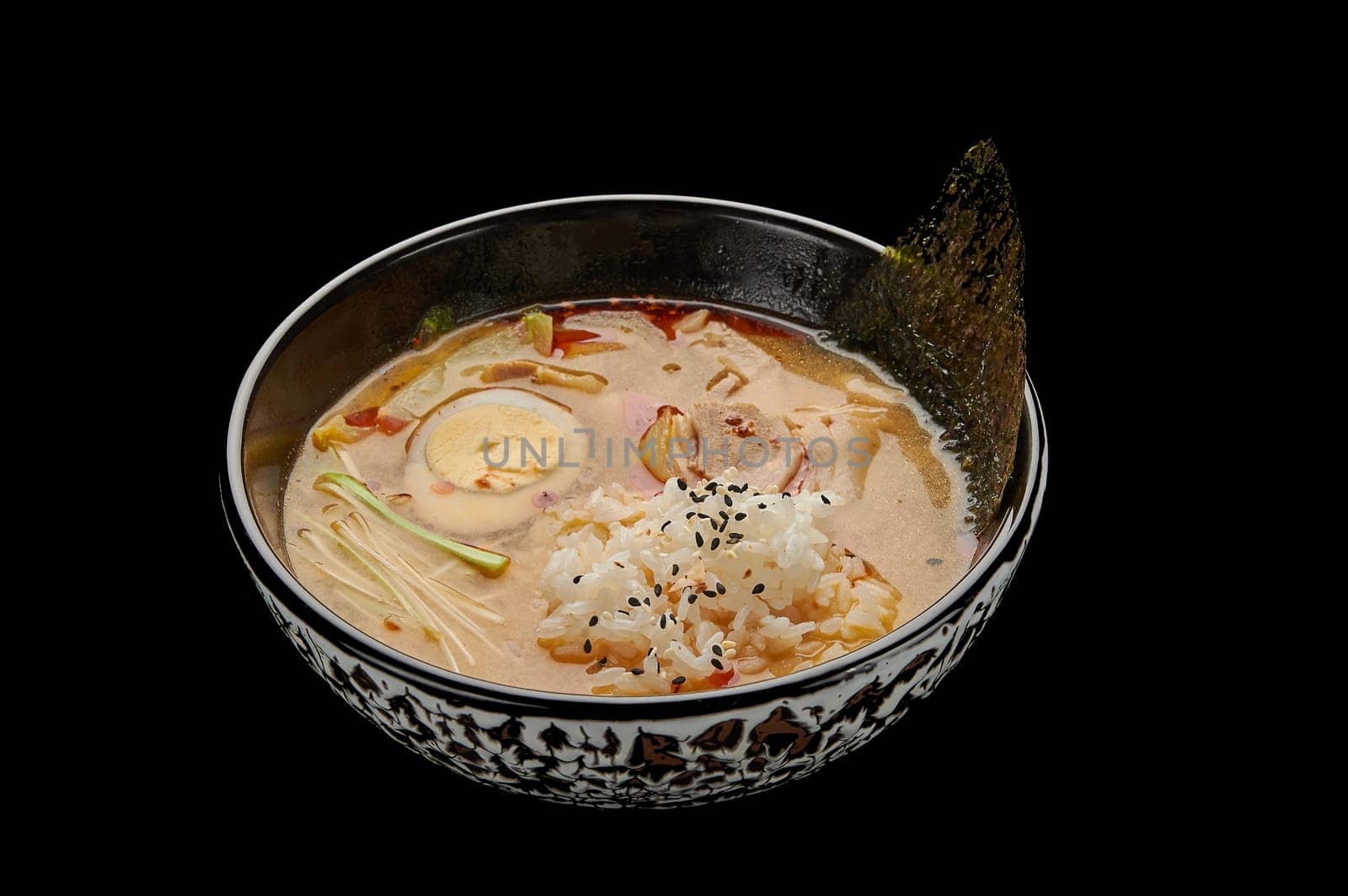 Kimchi Tige soup in a deep dish on a black isolated background. High quality photo