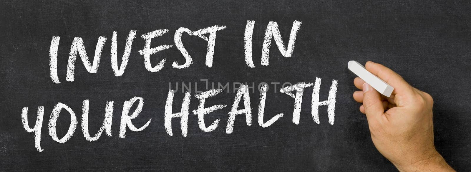 Text written on a blackboard - Invest in your health