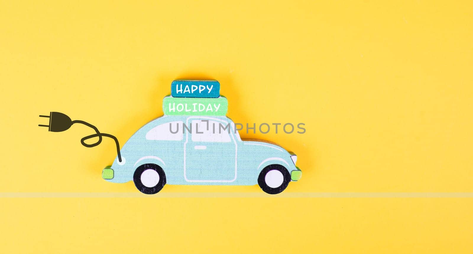 Small blue electric car with a cable for recharging, vacation trip with eco power