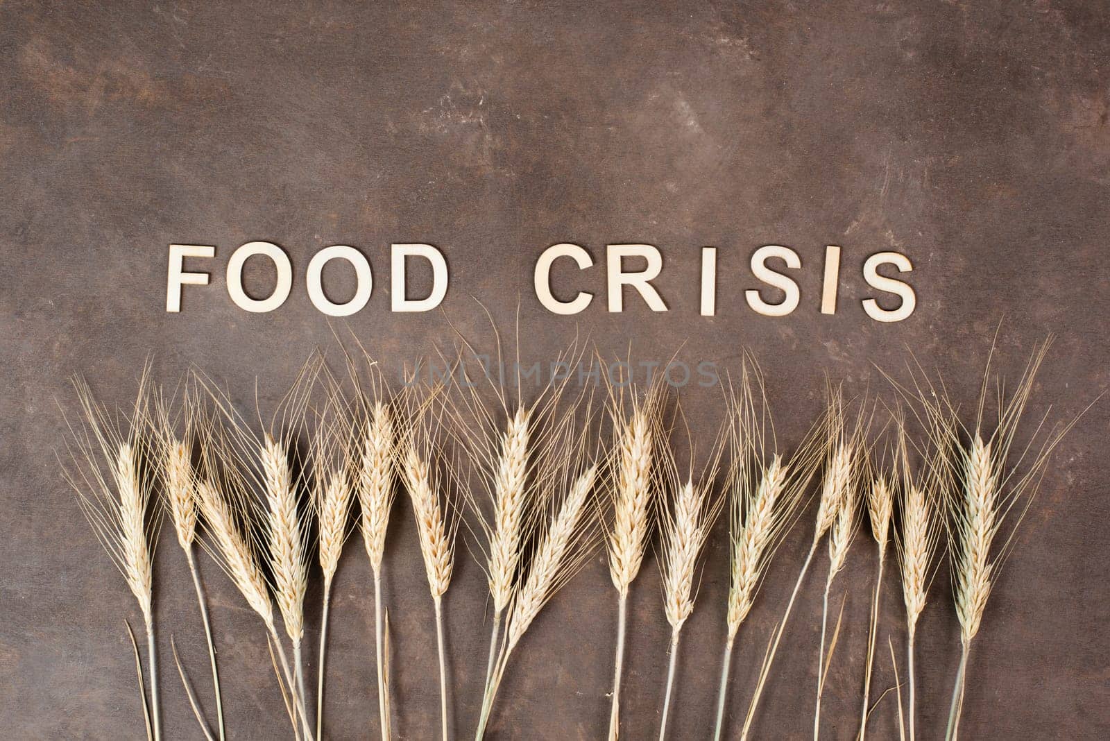 Food crisis with increasing prices and shortages, wheat ears on a brown background, supply chain problems, inflation causes high living costs