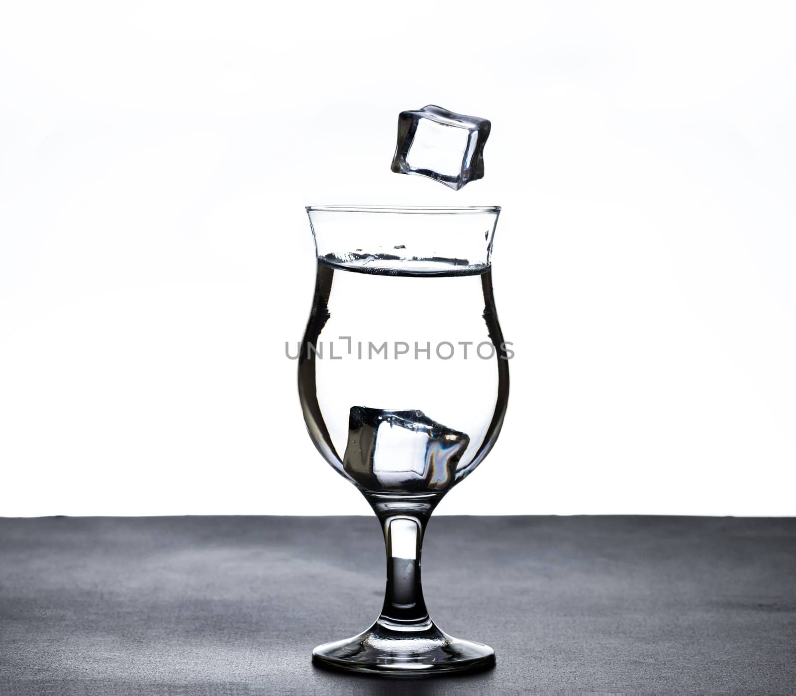 The image of pouring drinking water, into a glass, that makes one feel refreshed on blurred white background