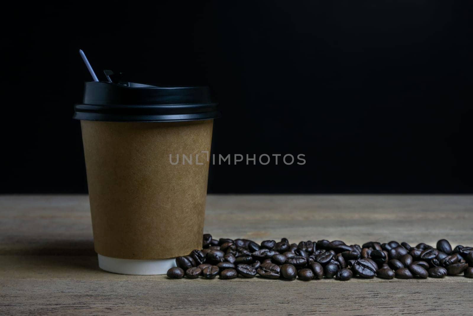 A cup of coffee with coffee bean, hot coffee on wooden background dark tone dtyle