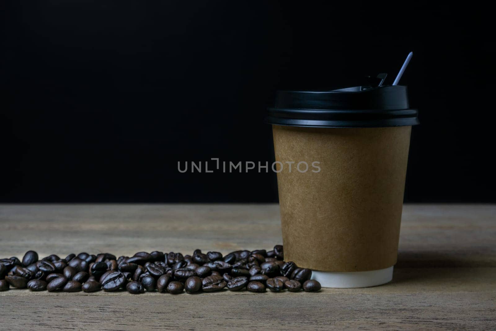 A cup of coffee with coffee bean, hot coffee on wooden background dark tone dtyle