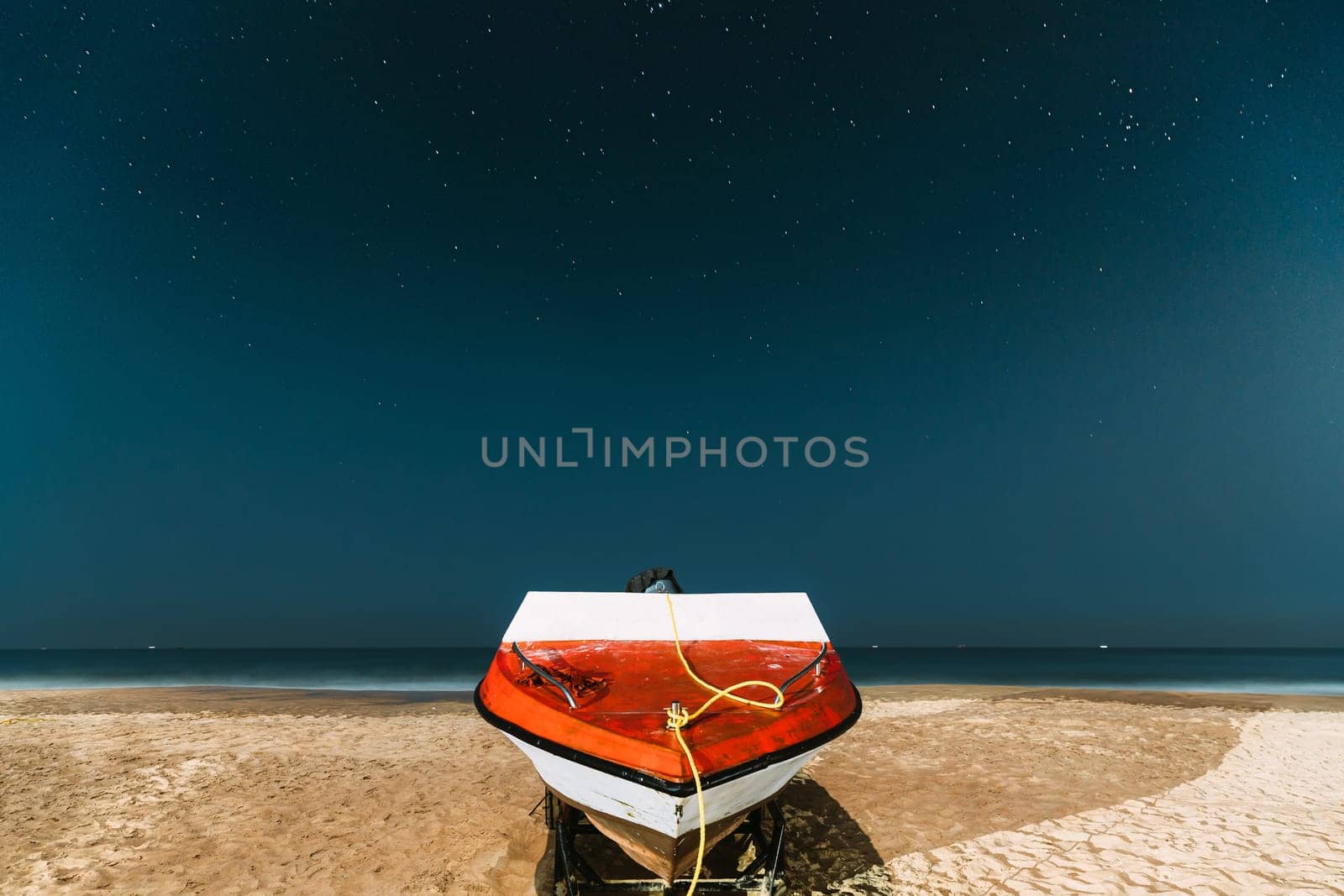 Goa, India. Real Night Sky Stars. Natural Starry Sky Blue Color Above Sea Seascape Ocean Beach. Background. Parked Boat At Coast.