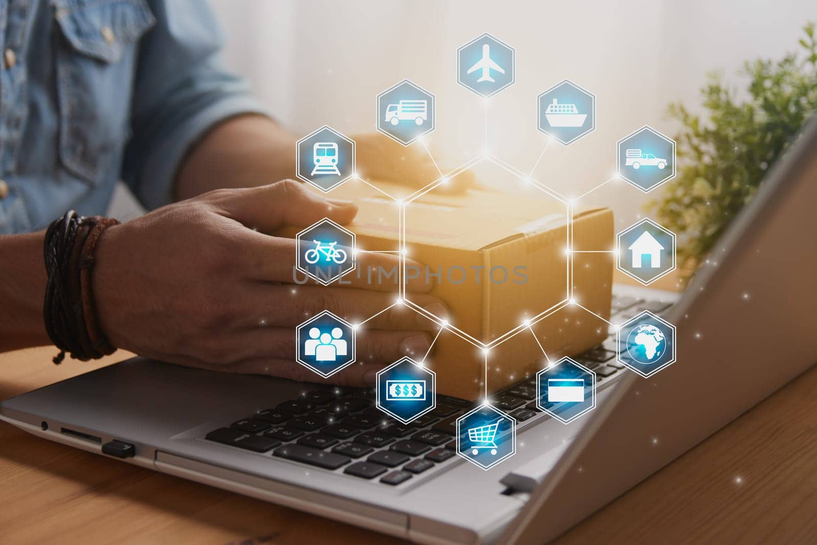 Hand of Casual Businessman or Entrepreneur Catch Parcel or Box on Laptop and Blue Hexagonal Logistic or Transportation Icon. SME Online Business and E-commerce Concept for Work at Home