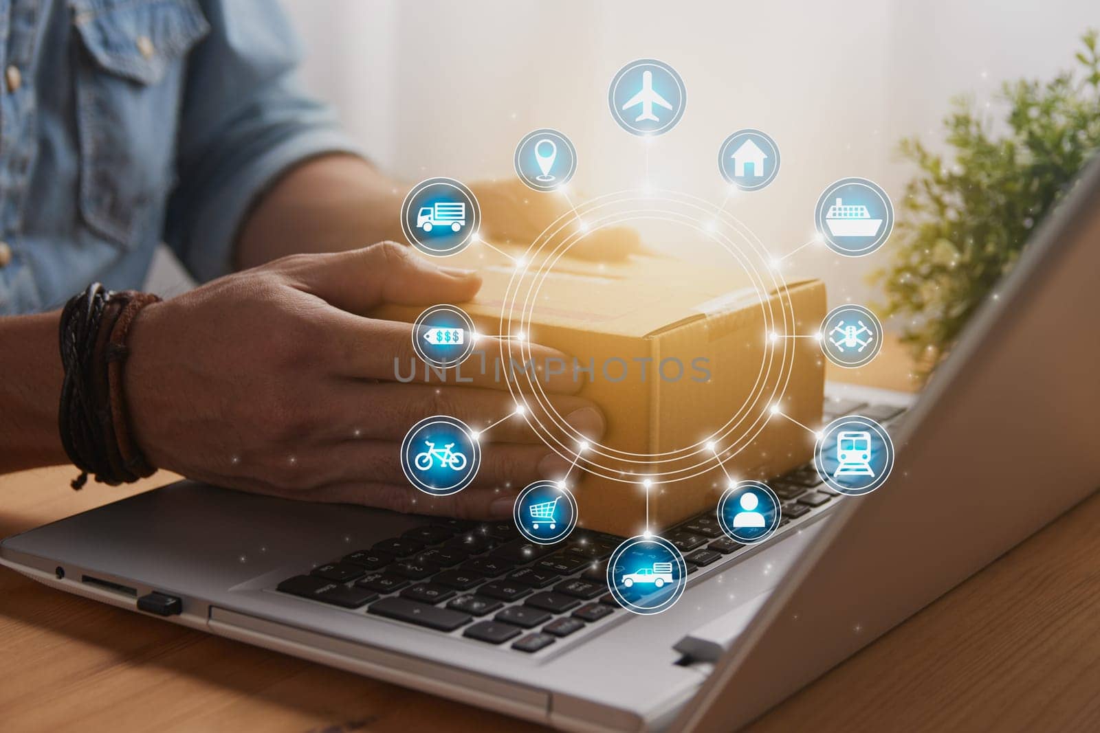 Hand of Casual Businessman or Entrepreneur Catch Parcel or Box on Laptop and Blue Circle Logistic or Transportation Icon. SME Online Business and E-commerce Concept for Work at Home