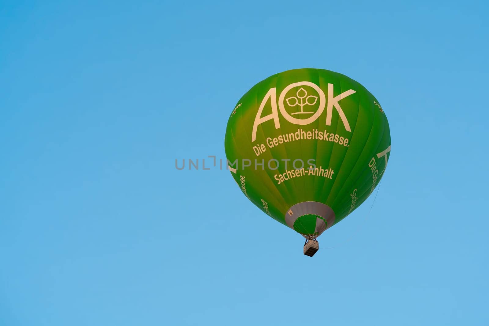 Hot air balloon with advertisement for health insurance AOK in the sky of Magdeburg in Germany